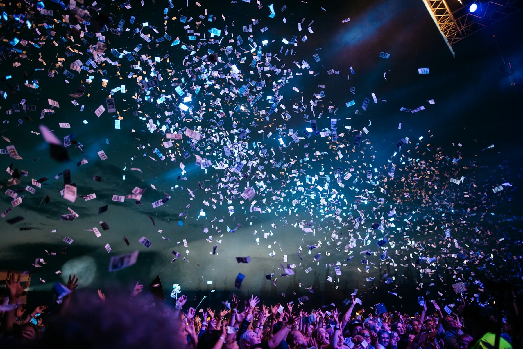 A crowd beneath violet stage lights and a sky of falling confetti